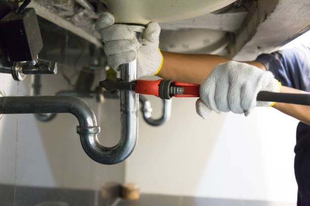 plumber Midvale UT fixing white sink with wrench